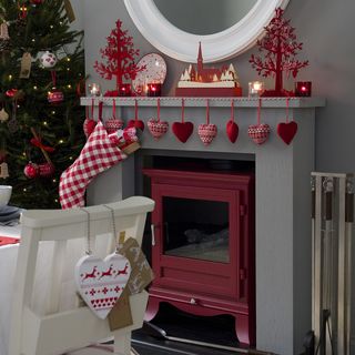 Mantelpiece and tree decorated with red Christmas decorations