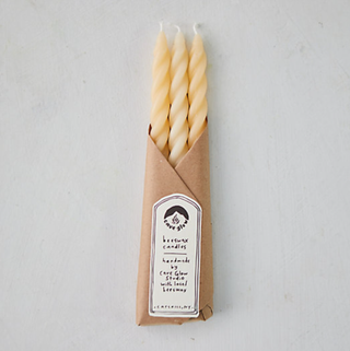 cream twisted candles in a brown paper packet