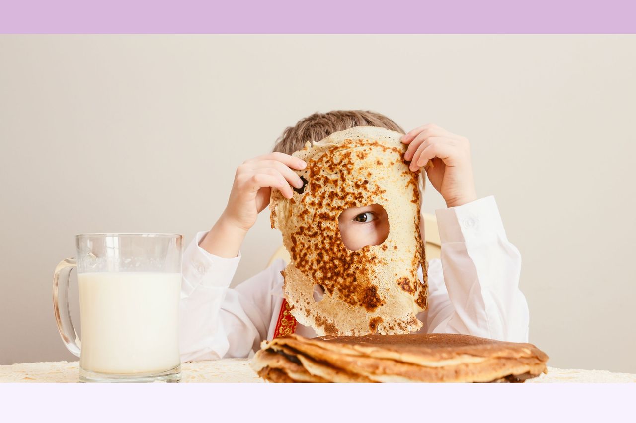 kid holding pancake with hold bitten out up to his eye