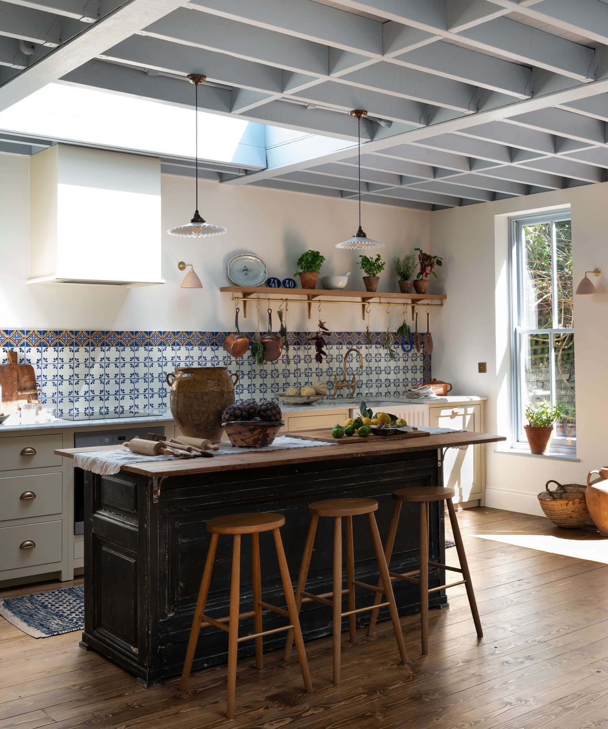 A cream and blue kitchen with a rustic vintage island