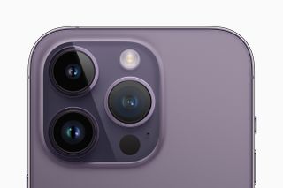 iPhone 14 Pro in purple colourway showing rear camera close up on white background