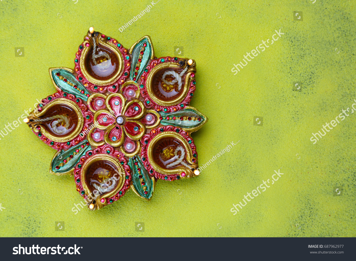 Clay diya lamps on a rangoli background during a Divali celebration by Dhirendrasingh K. Bais