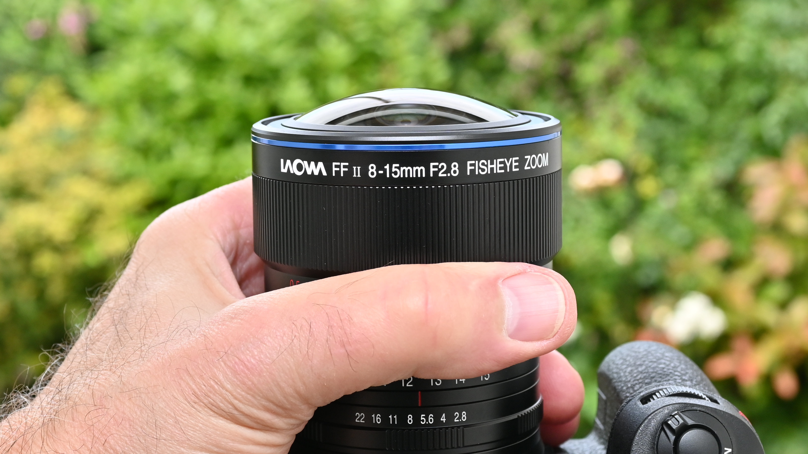 Laowa 8-15mm f/2.8 FF Zoom Fisheye product image of lens held in hand