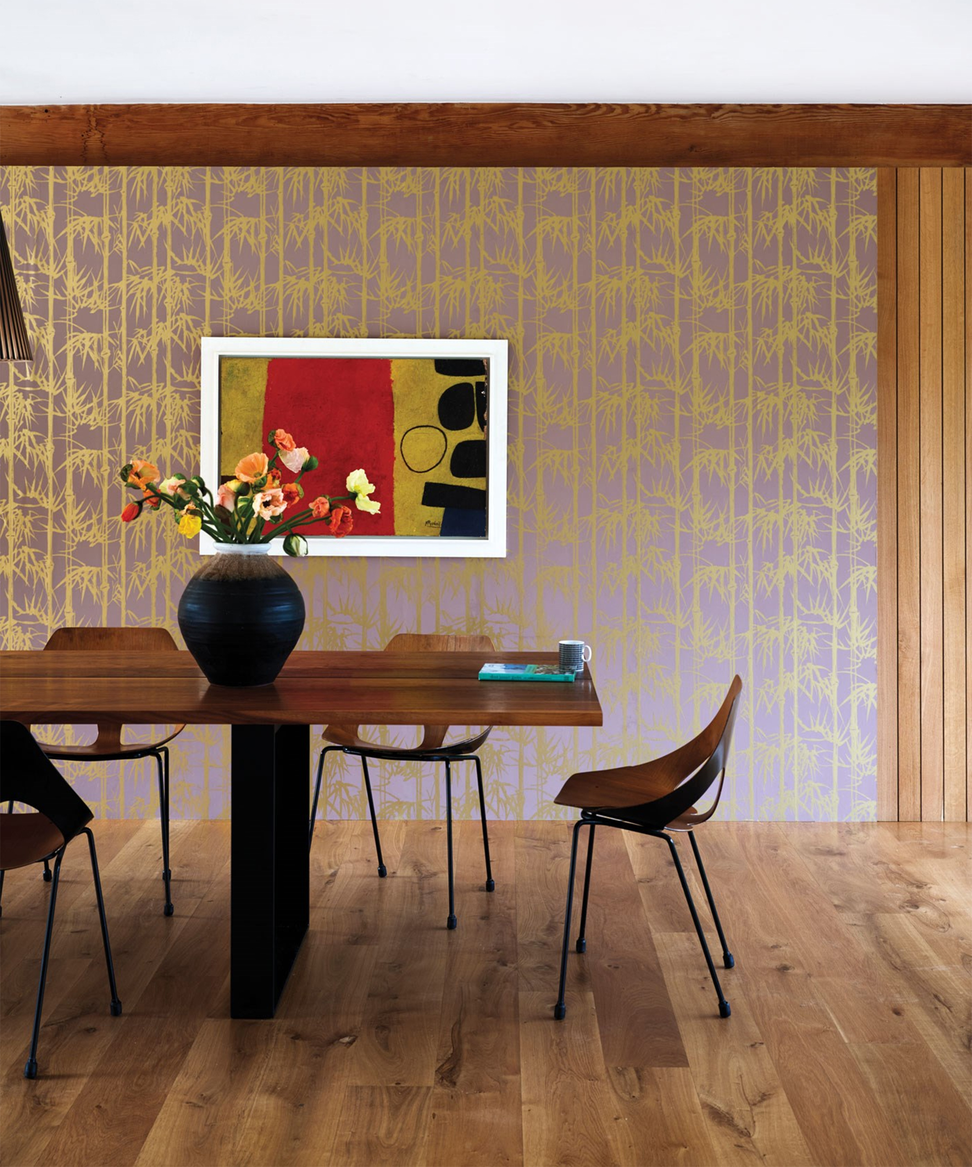Seventies inspired dining area with wooden dining table and bamboo motif printed wallpaper design