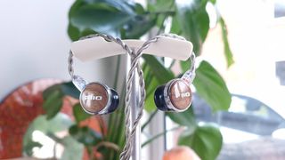 FiiO FP3 wired earbuds hanging off an upright stand