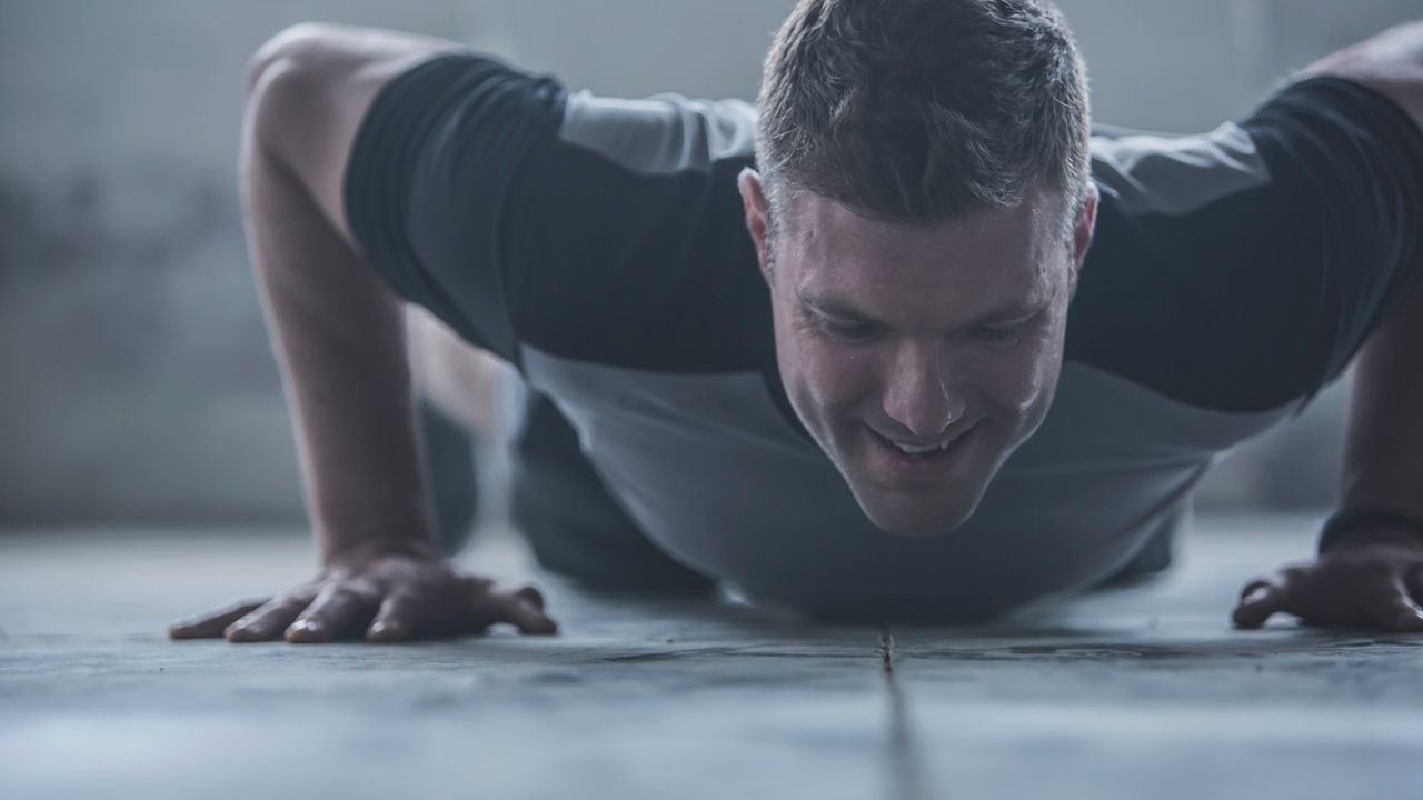 A man doing a HIIT workout performing a push up 