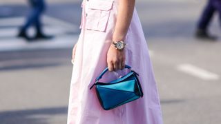milan, italy february 23 a guest wears a watch, a pink dress, a blue loewe bag, outside boss, during milan fashion week fallwinter 2020 2021 on february 23, 2020 in milan, italy photo by edward berthelotgetty images