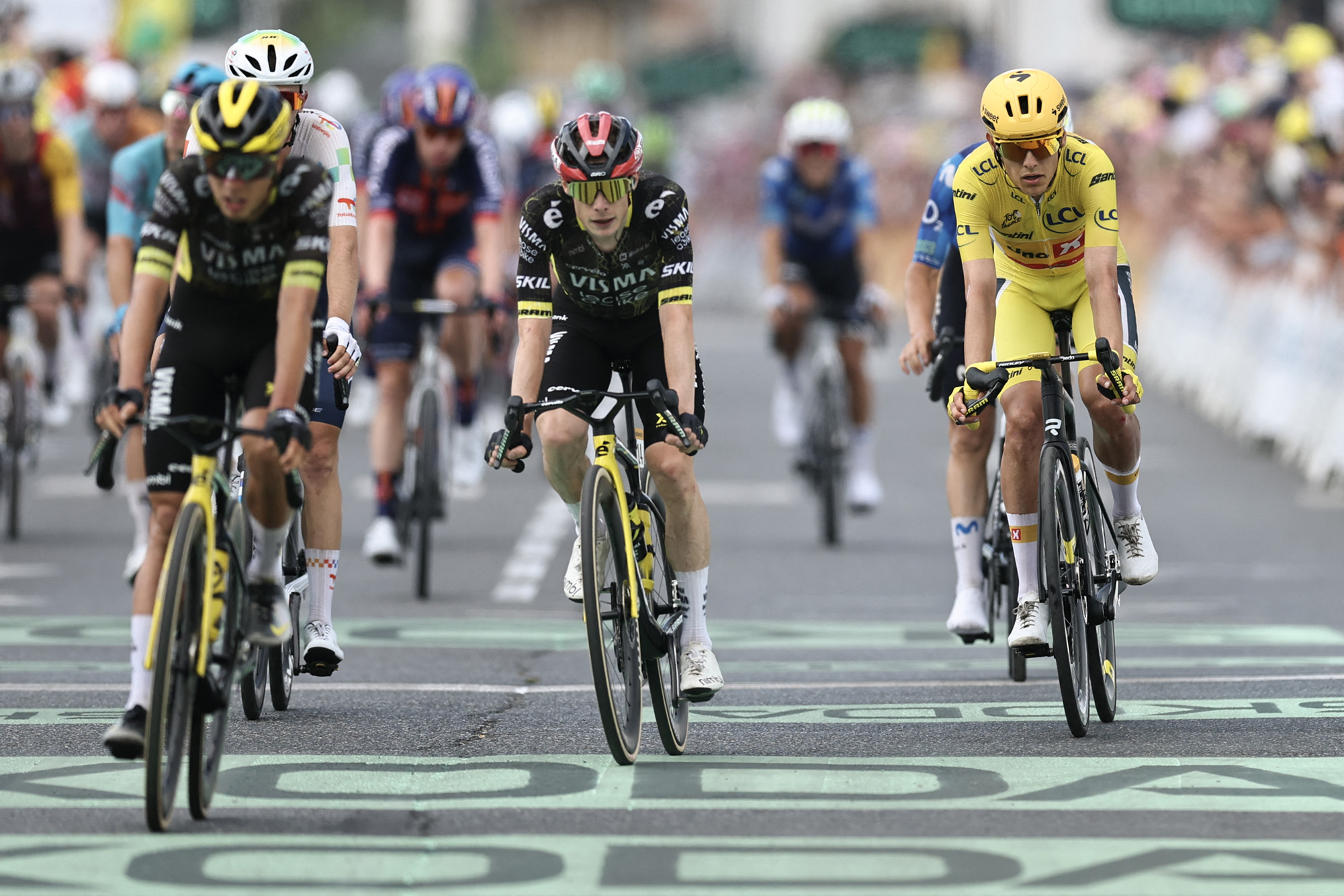 Uno-X Mobility team's Norwegian rider Torstein Traeen wearing the overall leader's yellow jersey (R) and Team Visma | Lease a Bike's Danish rider Jonas Vingegaard (C) cross the finish line of the 5th stage of the 113th edition of the Tour de France cycling race, 158 km between Lannemezan and Pau in southwestern France, on July 8, 2026. (Photo by Anne-Christine POUJOULAT / AFP via Getty Images)