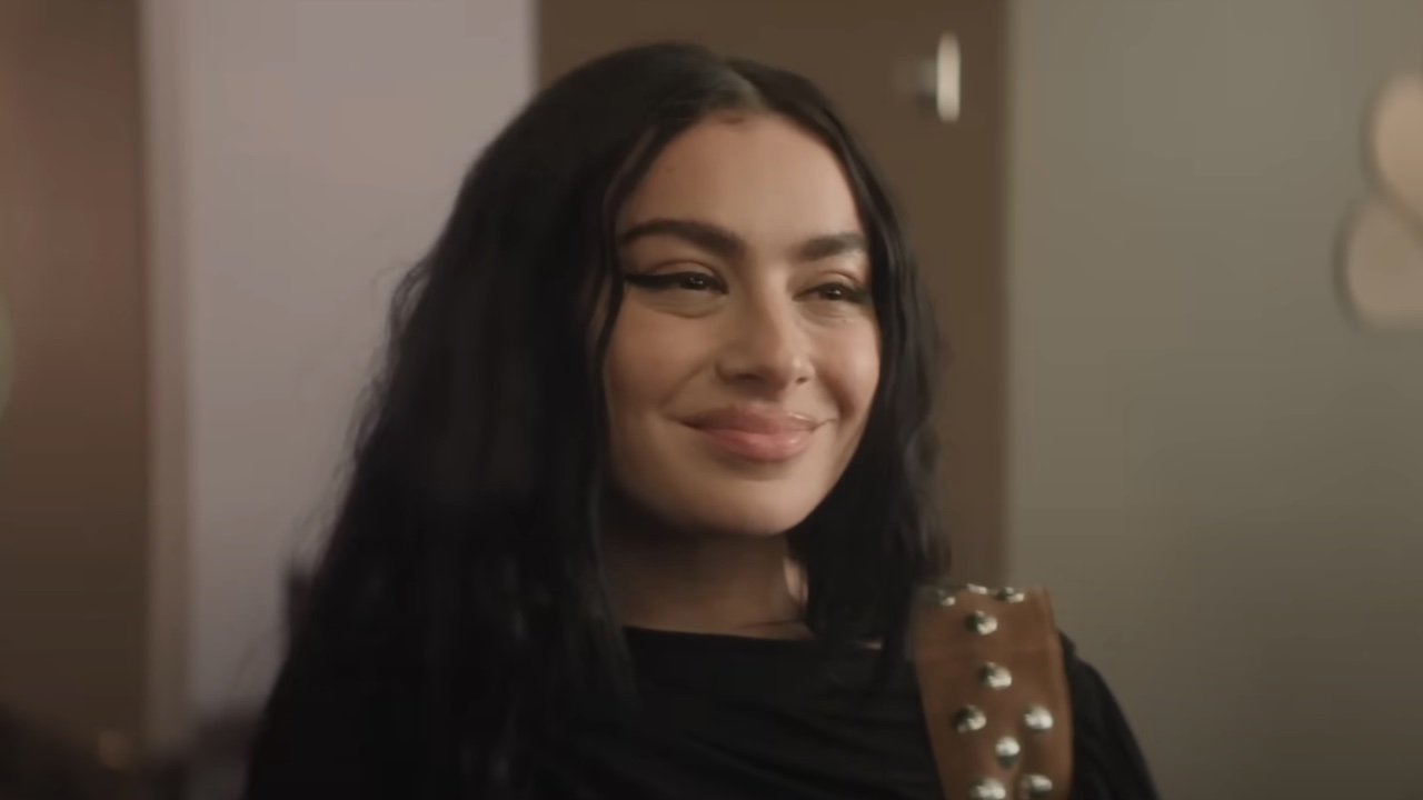Charli XCX smiling in Please Don't Destroy's "Mean Cute" short on Saturday Night Live