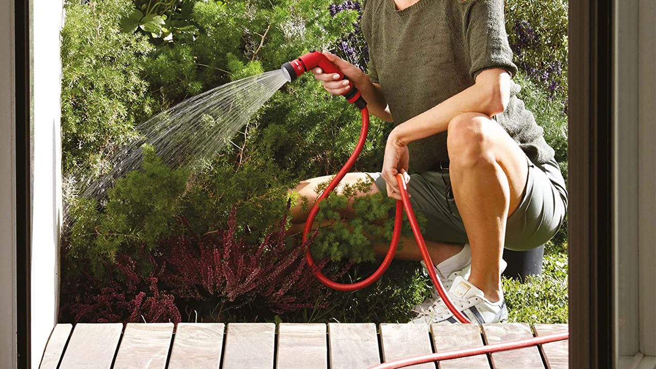 YoYo Self-Extending Hosepipe being used by a woman to water some bushes