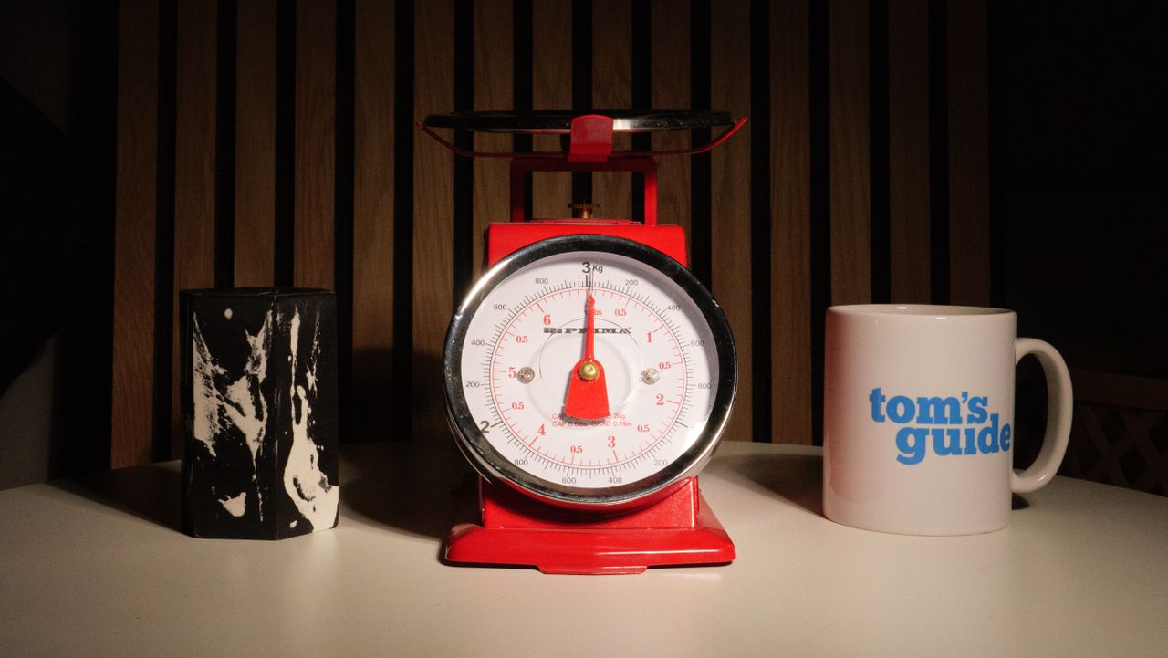 A photo of a set of red scales next to a Tom's Guide mug