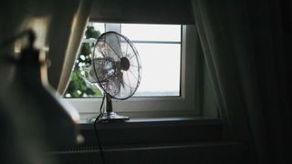 picture of fan on in dark room near window