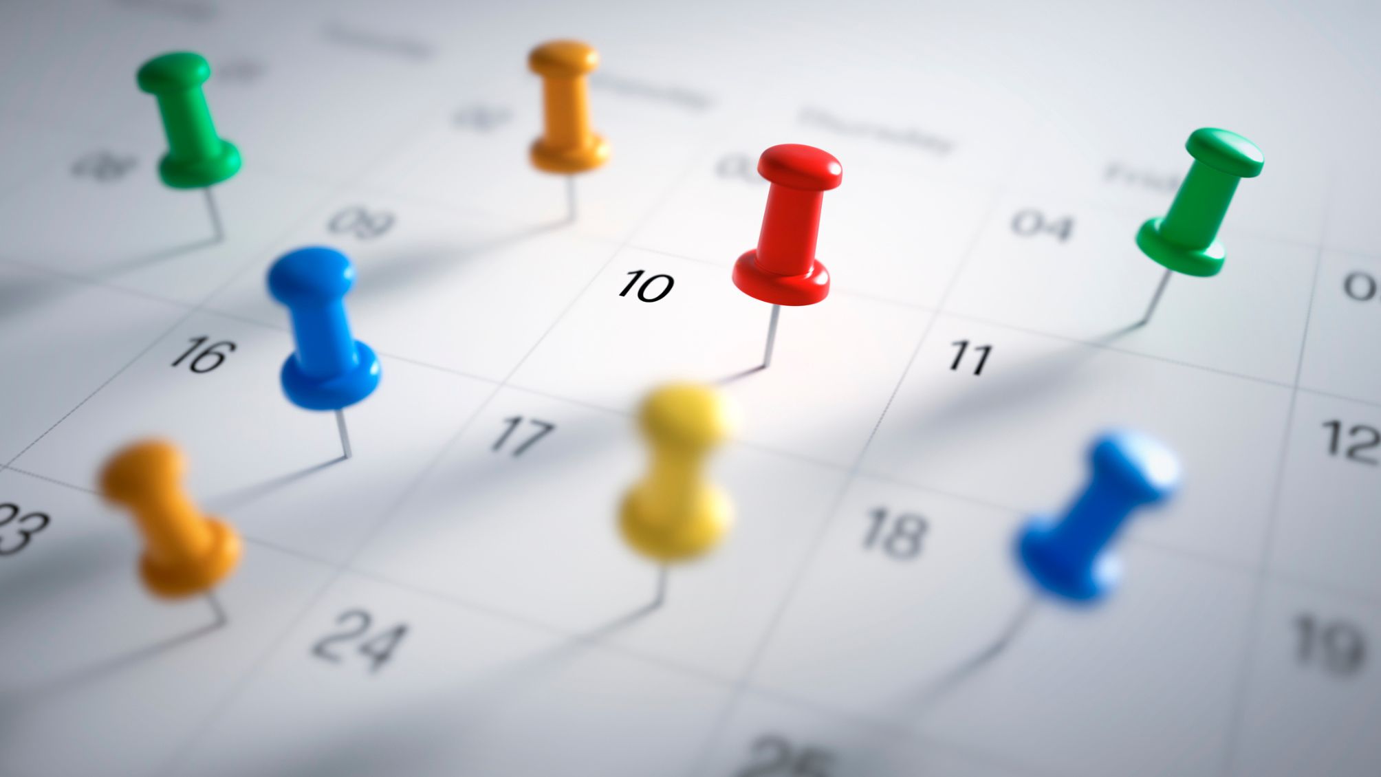 Thumb tacks pushed into a calendar