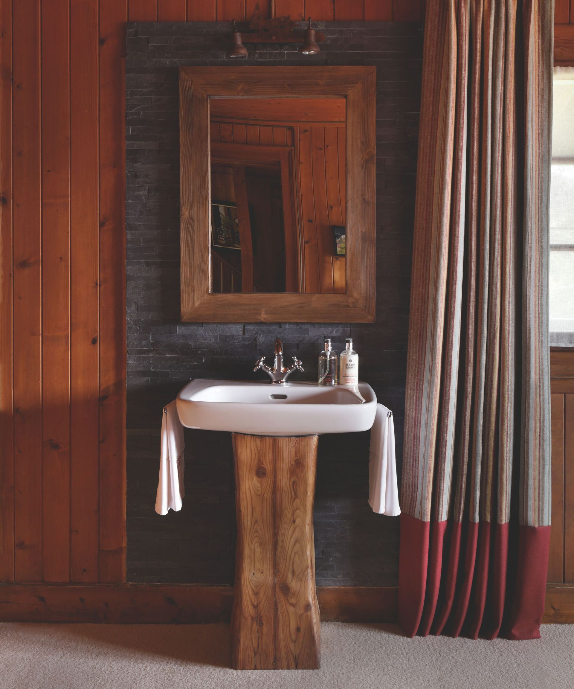 bathroom with wooden wall, sink base and mirror