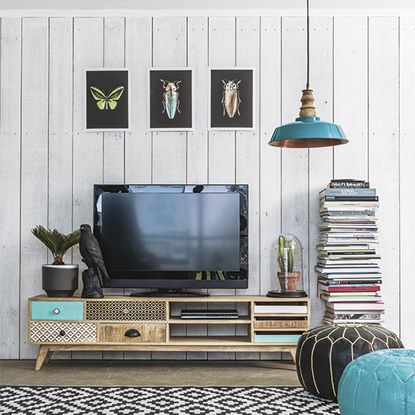 living room with smart tv on wooden desk and white wooden wall