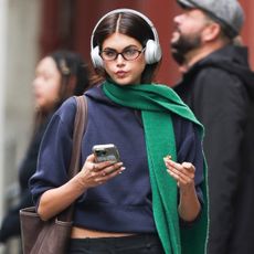 Kaia Gerber walks in Manhattan wearing low rise pants and a sweater