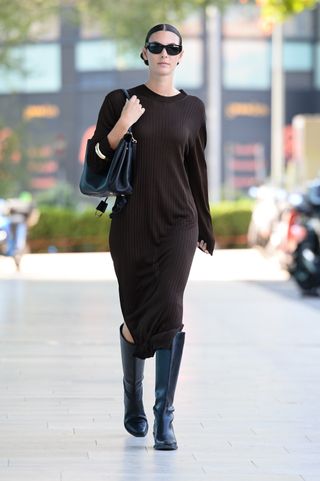 Vittoria Ceretti wears a sweaterdress and boots while off-duty during Milan Fashion Week