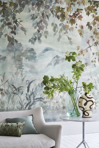 Plants and cushions complement the tones and themes of the wallpaper