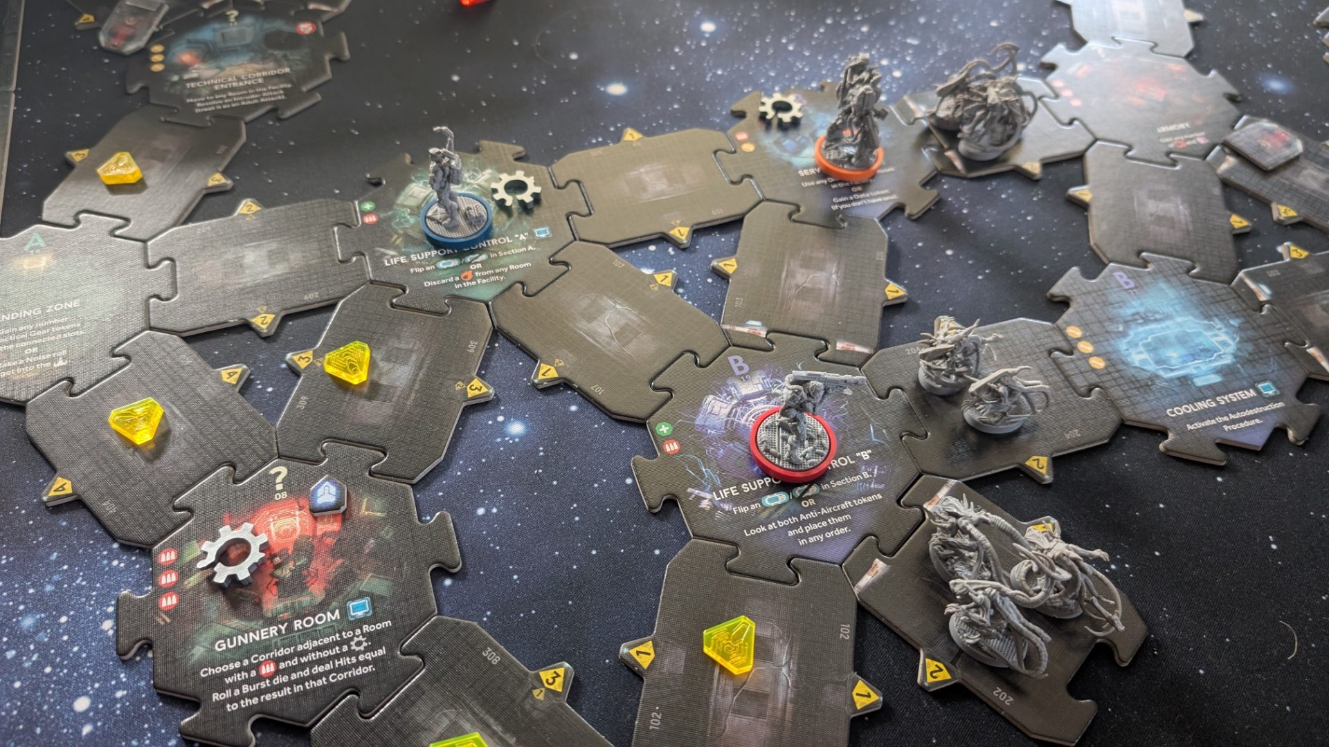 Nemesis: Retaliation pieces, board tiles, and tokens on a gaming table with a starry effect
