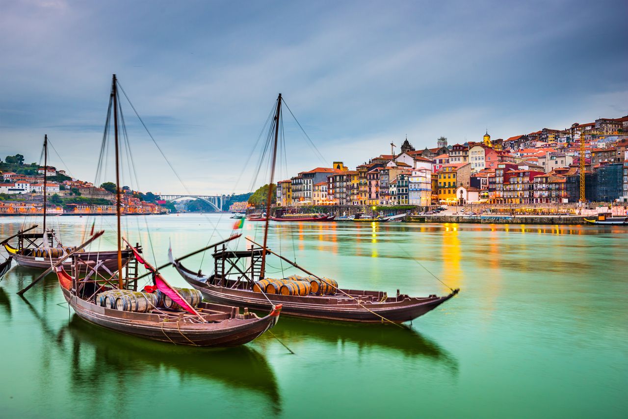 three boats on the water at Porto Portugal with city landscape in the background