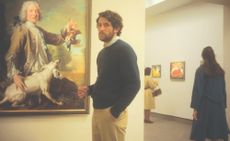 Josh O'Connor poses in front of a painting