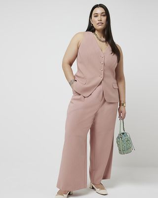 Woman in pink waistcoat and trousers