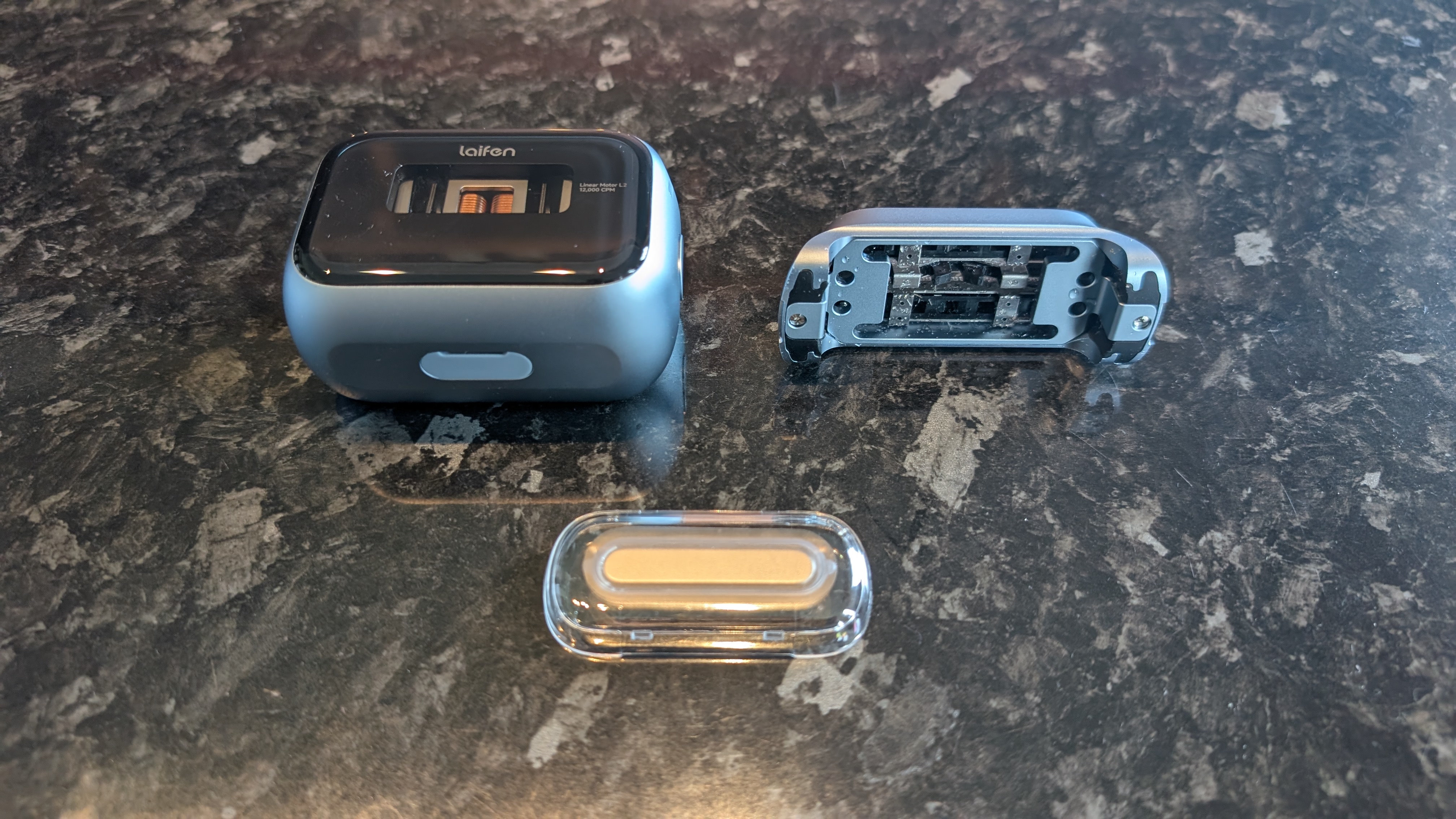 The Laifen P3 Pro electric travel shaver pictured disassembled on a dark marble worktop.