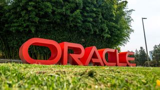 A low angle photo of an Oracle Corp. sign displayed on a grass verge