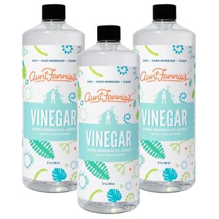 Three clear 33 ounce bottles of Aunt Fannie's Extra Strength Cleaning Vinegar with black twist caps