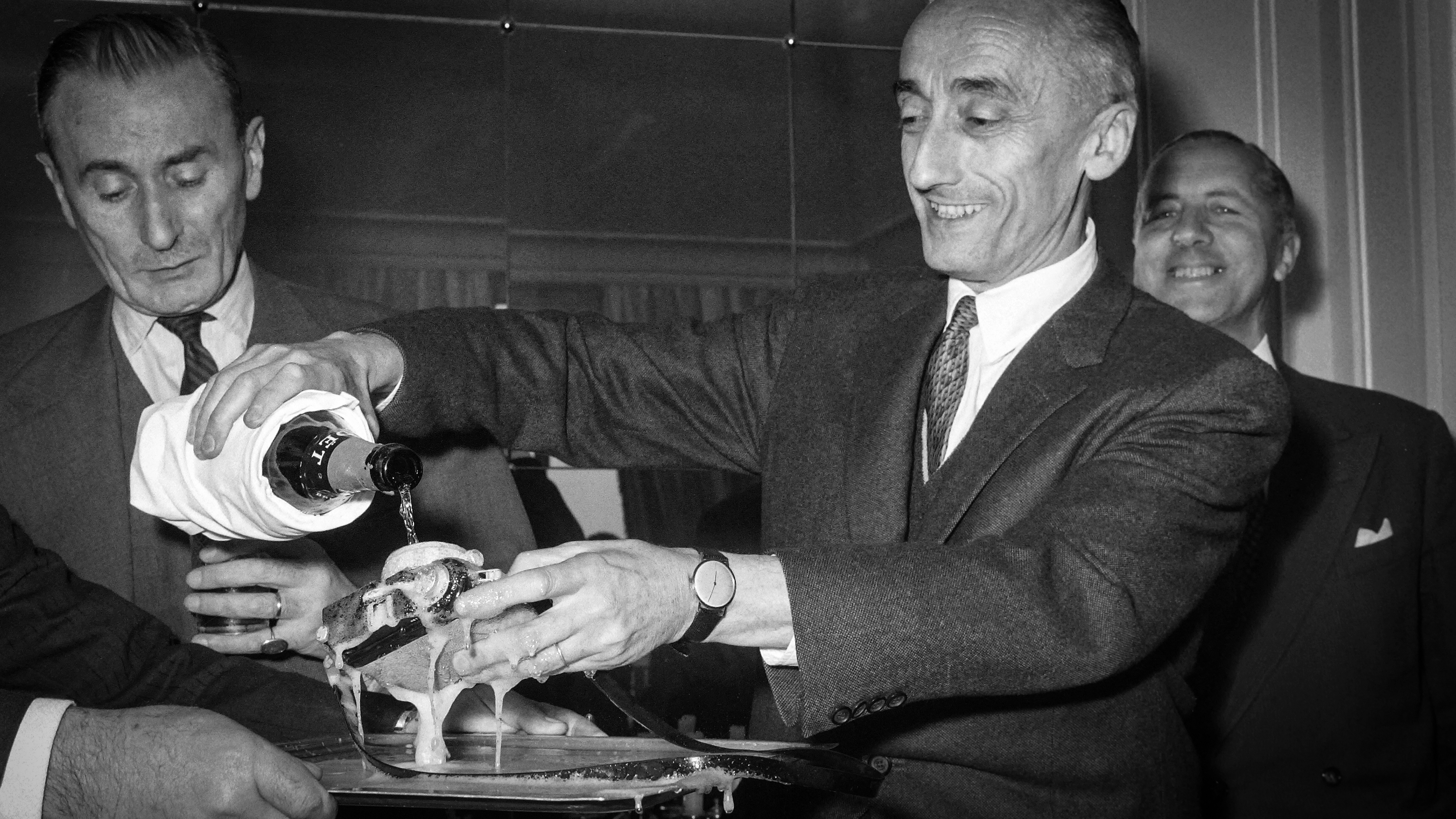 Commander Jacques-Yves Cousteau baptizes the "Calypso Phot", a completely waterproof small format camera, with champagne, to show its waterproofness, on April 12, 1962 in Paris. (Photo by AFP via Getty Images)