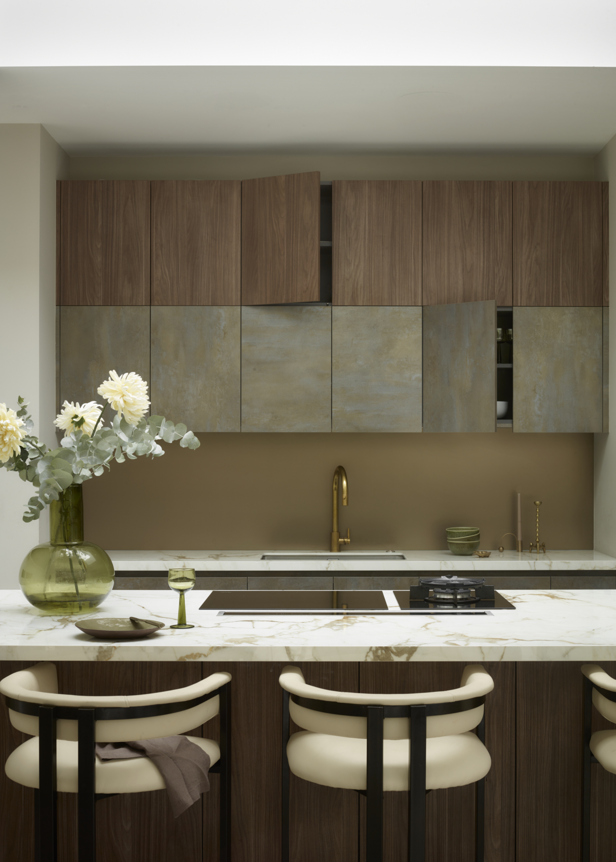 Warm, earthy toned kitchen with double height cabinets and a marble surface.