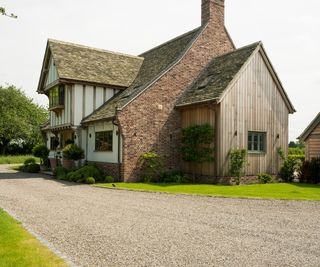 oak frame house with gravel driveway