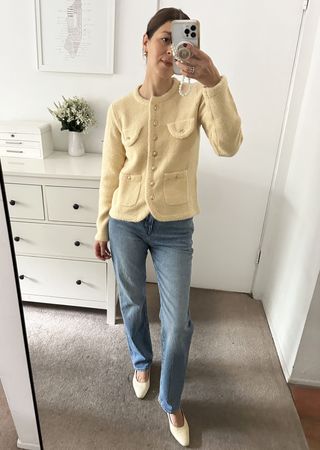 Woman in pale yellow sweater jacket and jeans.