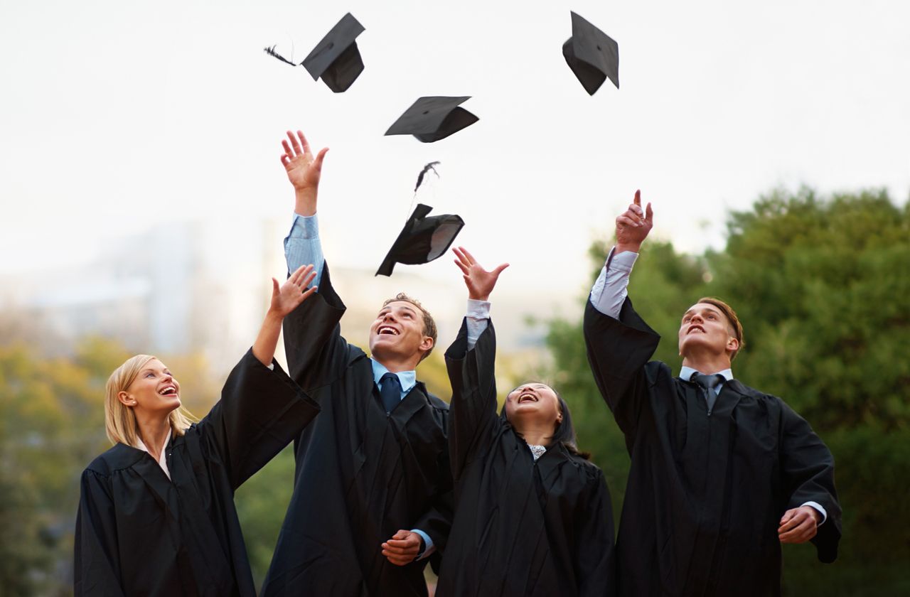 A group of students throwing their caps into the air after graduation