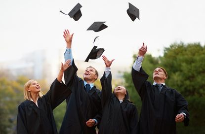 A group of students throwing their caps into the air after graduation