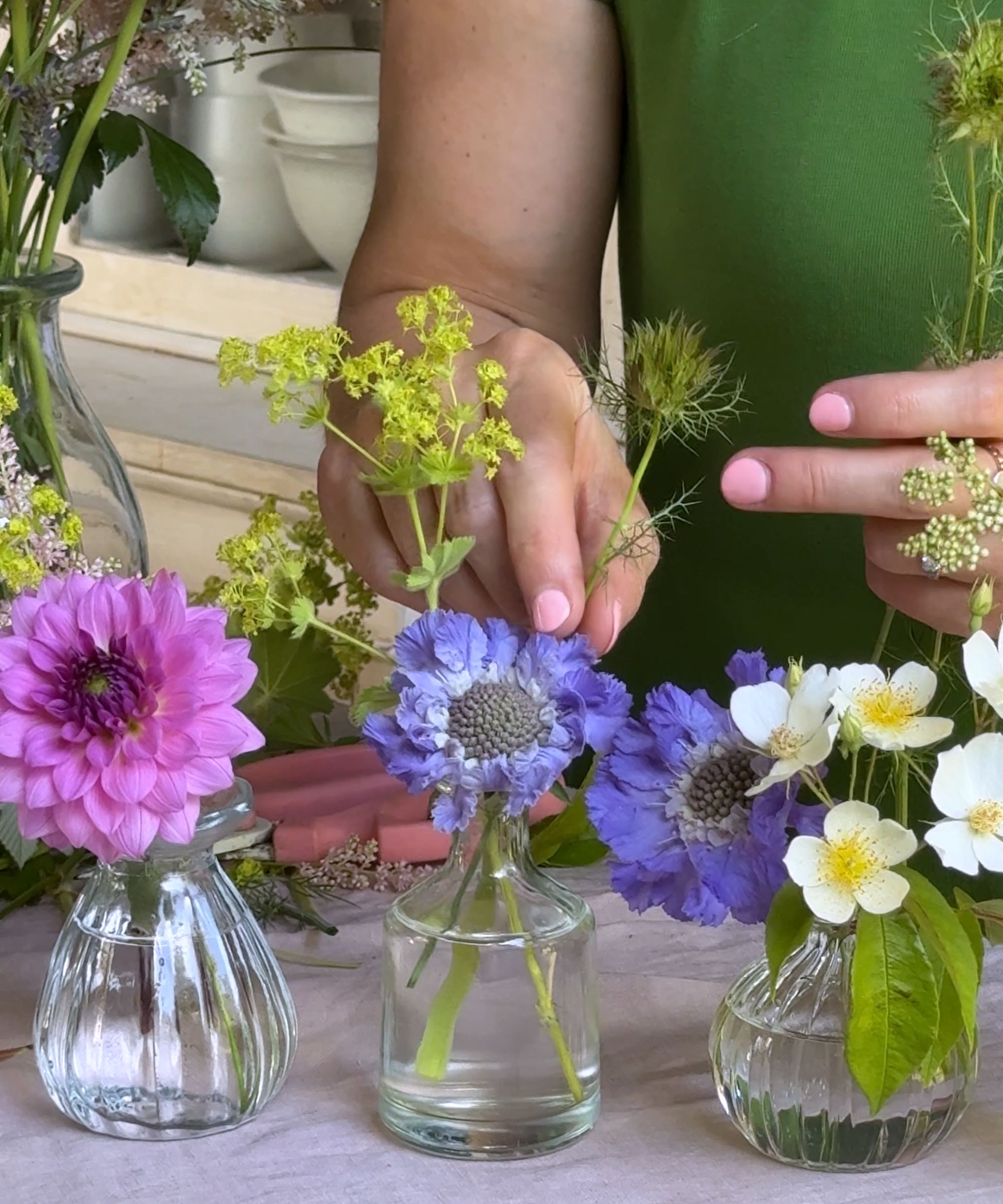 Flowers being arranged in bud vases