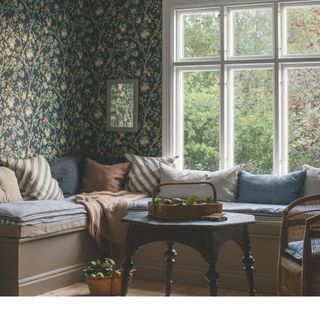 dining room with autumnal botanical wallpaper behind banquette seating