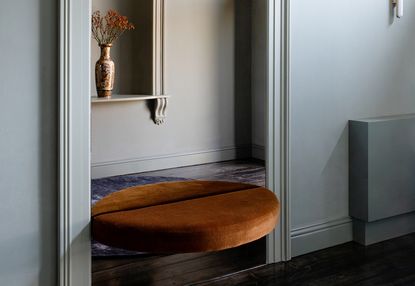 semi circular bench built into an alcove in a modern entryway