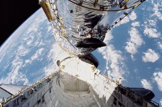 The Hubble Space Telescope is seen suspended above the space shuttle Discovery's payload bay before being deployed into orbit by the STS-31 crew on April 25, 1990.