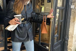 French girl wearing a leather jacket and jeans with a Burberry bag