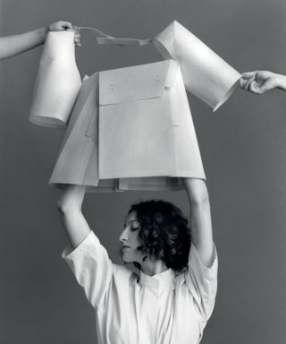 Woman putting on a shirt made from cardboard
