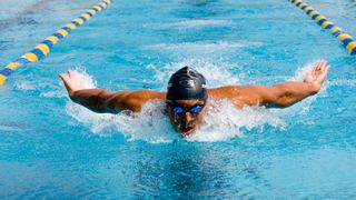 Man doing butterfly swimming stroke in the pool, the best swim stroke for burning calories