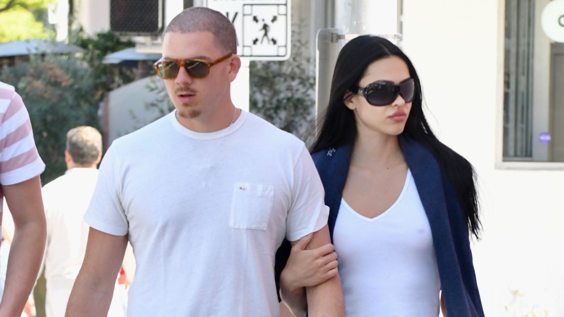 Amelia Grey Hamlin wears long shorts with a white tank top and black loafers.