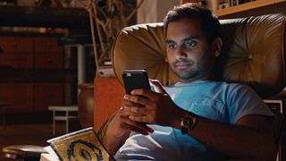 Aziz Ansari as Dev, staring at his phone in Master of None