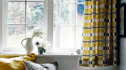 open window and yellow curtain with window seat and flowers