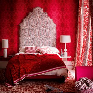 king size bed with wallpaper on wall and curtains
