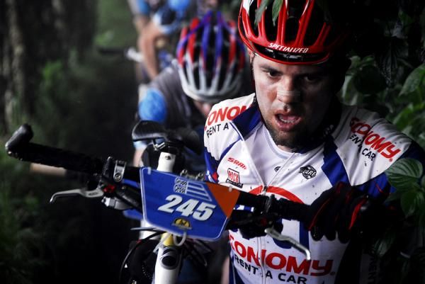 Race leader Deiber Esquivel carries his bike through a tricky section.