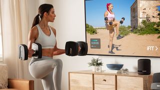 Woman uses NordicTrack adjustable dumbbells in front of iFit fitness app on TV