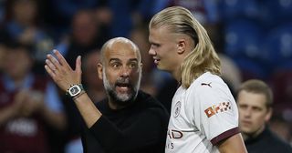 Manchester City manager Pep Guardiola speaks with Erling Haaland of Manchester City as they walk off the pitch at half time during the Premier League match between Burnley FC and Manchester City at Turf Moor on August 11, 2023 in Burnley, England.