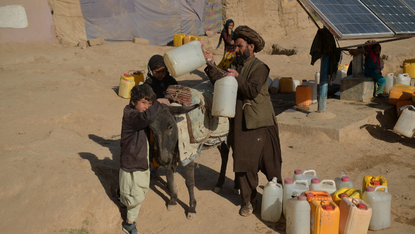 Family collect water containers during drought in Afghanistan